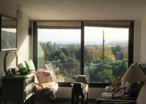 a living room with a large window with a view at Veranda Sopra di Cala d'Ambra e Ogliastra in San Teodoro