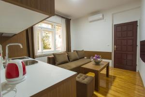 a kitchen and a living room with a couch at Apart AS in Mostar