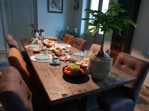 een houten tafel met een potplant erop bij Bed & Breakfast Huis Sevenaer in Zevenaar