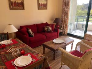 a living room with a red couch and a table at SWING RESIDENCE GOLF LA BAULE in Saint-André-des-Eaux