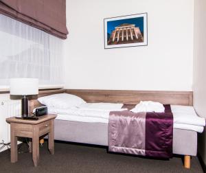 ポズナンにあるWILla Medicaのベッドルーム1室(ベッド1台、ランプ付きテーブル付)