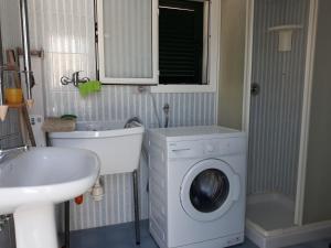 a bathroom with a washing machine and a sink at casa gialla mare del salento in Maruggio