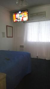 Habitación con TV, cama y ventana. en Roberta en Bahía Blanca