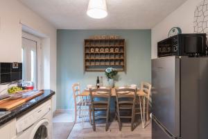 uma cozinha com uma mesa com cadeiras e um frigorífico em Snowdon Snug em Llanberis