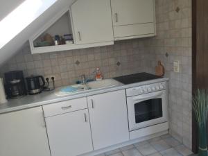 a kitchen with white cabinets and a sink at Ferienwohnungen Tauscher in Sankt Martin