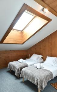 two beds in a room with a skylight at Appartement Le Caboen Les Planards in Chamonix-Mont-Blanc