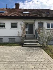 a white house with a brick driveway at Gästezimmer Süß- Scharf in Meckenbeuren