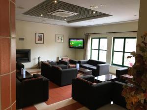 a waiting room with couches and a flat screen tv at Viseu Garden Hotel in Viseu