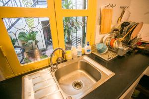 a kitchen counter with a sink and a window at Barn1920s Hostel in Vientiane