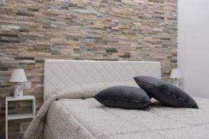 a bedroom with a bed with two pillows and a brick wall at La Tradizione in Bari