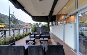 a patio with chairs and tables on a balcony at Ai Ronchi Motor Hotel Brescia in Brescia