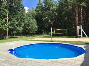 a large blue pool in a park with a goal at Willa bankietowa z basenem in Papiernia