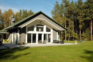 a house with a black roof and a yard at Willa bankietowa z basenem in Papiernia