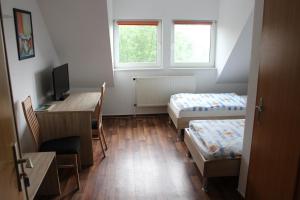 Habitación con 2 camas y escritorio con ordenador. en Pension Dräger, en Mühl Rosin