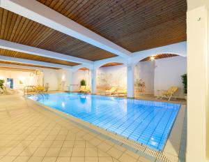 a swimming pool in a hotel with a large building at Parkhotel Tristachersee in Lienz