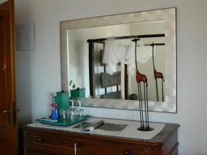 - un miroir au-dessus d'une commode dans la salle de bains dans l'établissement Aurora Suite apartment, à Pettenasco