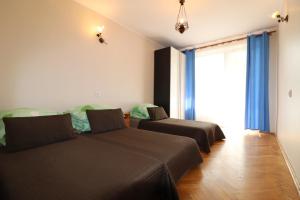 a bedroom with two beds and a large window at Gorce apartamenty i pokoje in Rabka-Zdrój