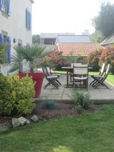 a patio with a table and chairs in a yard at chambres d'hôtes les mésanges avec salle d'eau privative pdj compris in Kersaint-Plabennec