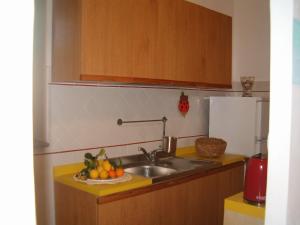 una cucina con lavandino e cesto di frutta di Pietra Fiorita a Pisciotta