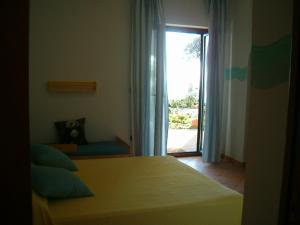 Schlafzimmer mit einem Bett und einer Glasschiebetür in der Unterkunft Pietra Fiorita in Pisciotta