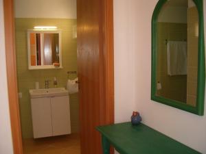 ein Bad mit einem Waschbecken und einem Spiegel in der Unterkunft Pietra Fiorita in Pisciotta