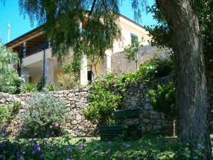 eine Steinmauer mit einer Bank vor einem Haus in der Unterkunft Pietra Fiorita in Pisciotta