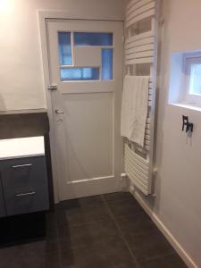 a bathroom with a white door and a window at Un grand jardin en ville. Chez Guy in Brussels