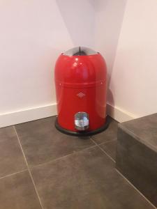 a red cooler sitting on the floor in a room at Un grand jardin en ville. Chez Guy in Brussels