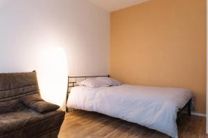 リモージュにあるAppartement cosy entièrement rénovéのベッドルーム(ベッド1台、ソファ付)