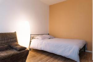 a bedroom with a bed and a couch at Appartement cosy entièrement rénové in Limoges