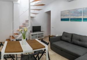 sala de estar con mesa y sofá en MALAMA Apartamentos Turísticos, en Málaga