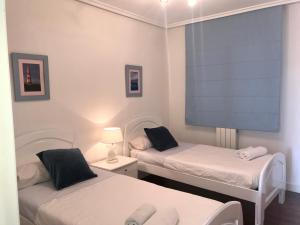 a room with two beds and a large screen at Apartamento PioXII Center in San Sebastián