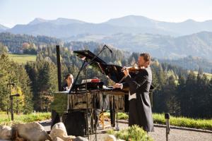 a man playing a violin and a woman playing a orchestra at Haubers Naturresort in Oberstaufen