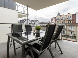 szklanym stołem i krzesłami na balkonie w obiekcie VacationClub – Stella Baltic Apartament 37 w Świnoujściu