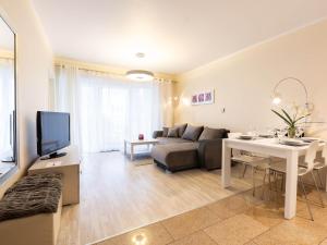 ein Wohnzimmer mit einem Sofa und einem Tisch in der Unterkunft VacationClub – Stella Baltic Apartament 37 in Świnoujście