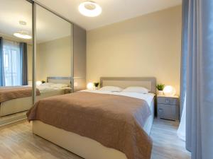 - une chambre avec un grand lit et un miroir dans l'établissement VacationClub – Stella Baltic Apartament 37, à Świnoujście