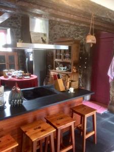 cocina con mesa y taburetes de madera en The Olive Tree Country Home en Vila Verde