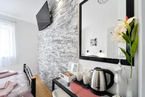 a room with a table with a coffee maker and a mirror at Apartments and Rooms Nekic in Zadar