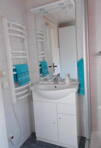 a white bathroom with a sink and a mirror at Ferienhaus am Langen See in Heidesee