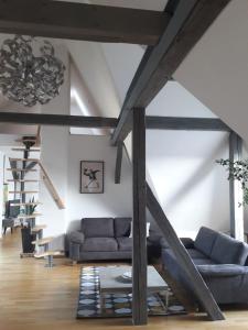 a living room with a couch and a staircase at Fair Messe Rooftop Loft in Nürnberg in Nuremberg