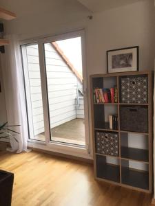 a living room with a large window and a book shelf at Fair Messe Rooftop Loft in Nürnberg in Nuremberg