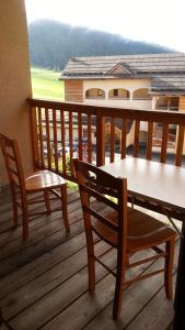 einen Balkon mit einem Tisch und Stühlen auf einer Terrasse in der Unterkunft Beau T3 ensoleillé au pied des pistes in Arvieux
