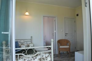 a bedroom with a bed and a chair in a room at Синя луна in Lozenets