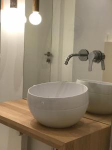 a white bowl sink on a wooden counter with a faucet at Nettes Appartment in Düsseldorf-Derendorf - stylisch + gemütlich in Düsseldorf