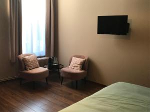 ein Hotelzimmer mit 2 Stühlen und einem TV in der Unterkunft B&B Inn Between in Gent