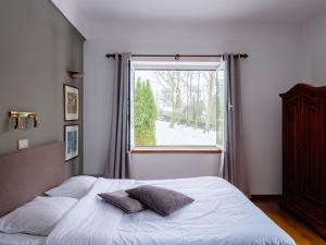 a bedroom with a bed and a large window at Hotel Auberge D'Alle in Alle