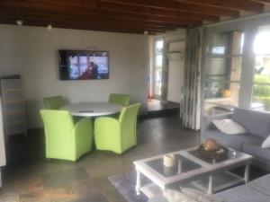 a living room with a table and green chairs at Vakantielogies Boerke Naas in Bruges