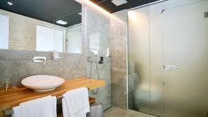 uma casa de banho com um lavatório e uma cabina de duche em vidro. em Sky Beach Aparthotel em Marina