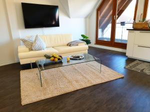 a living room with a couch and a glass coffee table at Seeperle 4 in Meersburg