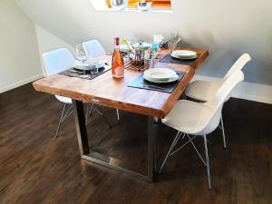 a wooden table with white chairs around it at Seeperle 4 in Meersburg